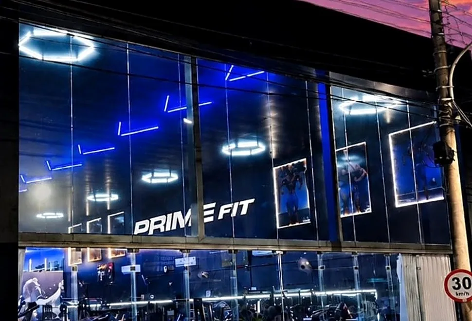 Vitrine da Prime Fit à noite, com o salão iluminado por luzes hexagonais